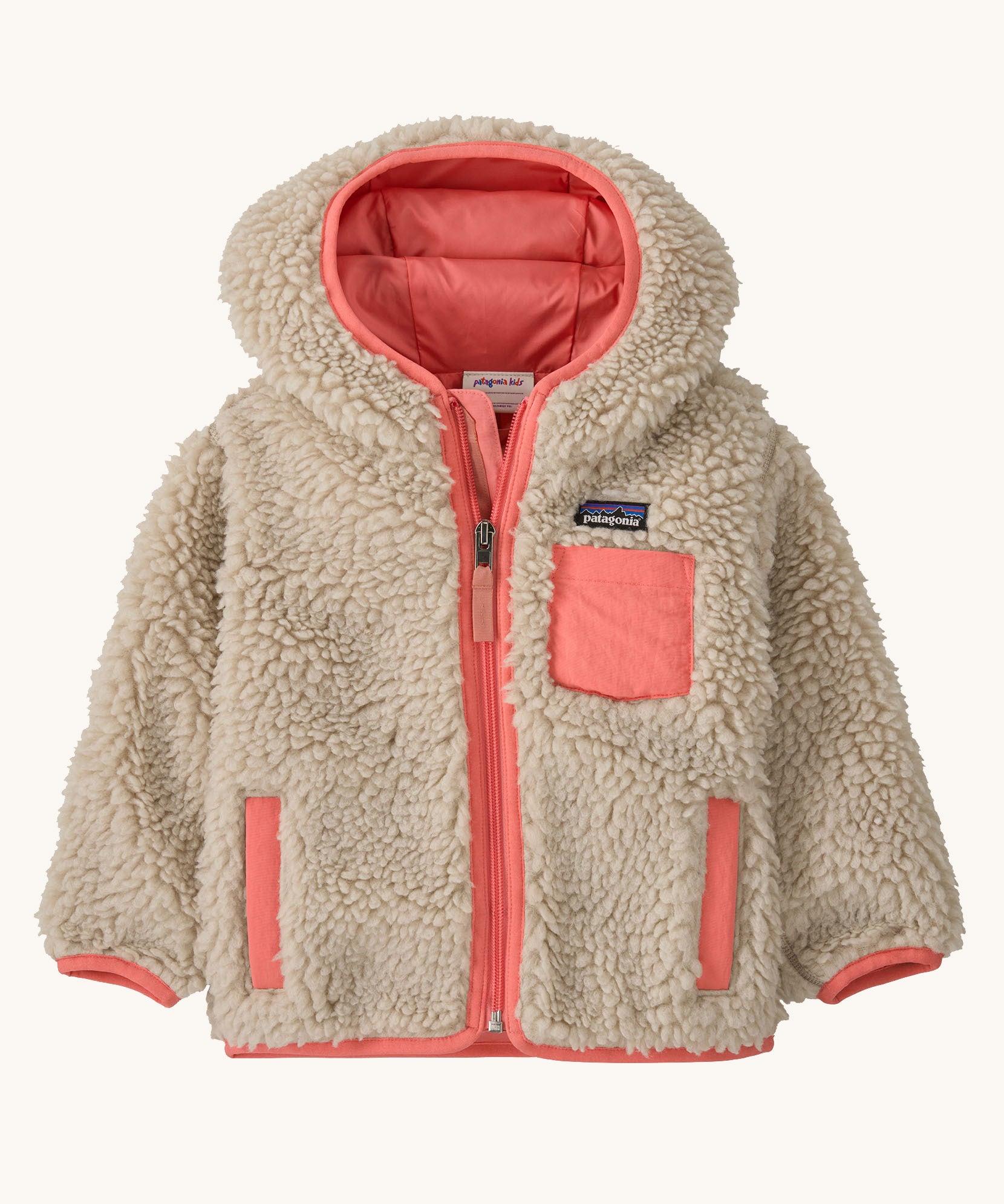 Patagonia little kids retro x hoody in dark natural available at Babipur. A 100% recycled polyester thick pile fleece hooded jacket in cream with pink trim Features a full length zip, 2 side pockets and a small chest pocket
