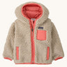 Patagonia little kids retro x hoody in dark natural available at Babipur. A 100% recycled polyester thick pile fleece hooded jacket in cream with pink trim Features a full length zip, 2 side pockets and a small chest pocket
