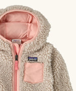 Patagonia little kids retro x pile windproof hooded fleece jacket in beige with a pink inner showing a close up of the pink chest pocket and front zip detail