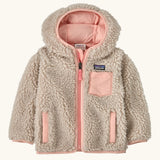 Patagonia little kids retro x pile windproof hooded fleece jacket in beige with a pink inner. Shows a full front zip, side and chest pockets