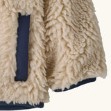 Patagonia little kids retro x pile fleece jacket in neutral showing a close up of the side pocket and cuff with navy trim