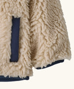 Patagonia little kids retro x pile fleece jacket in neutral showing a close up of the side pocket and cuff with navy trim