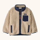 Patagonia little kids retro x pile fleece jacket in neutral with a navy trim. Shows a full front zip, side and chest pockets