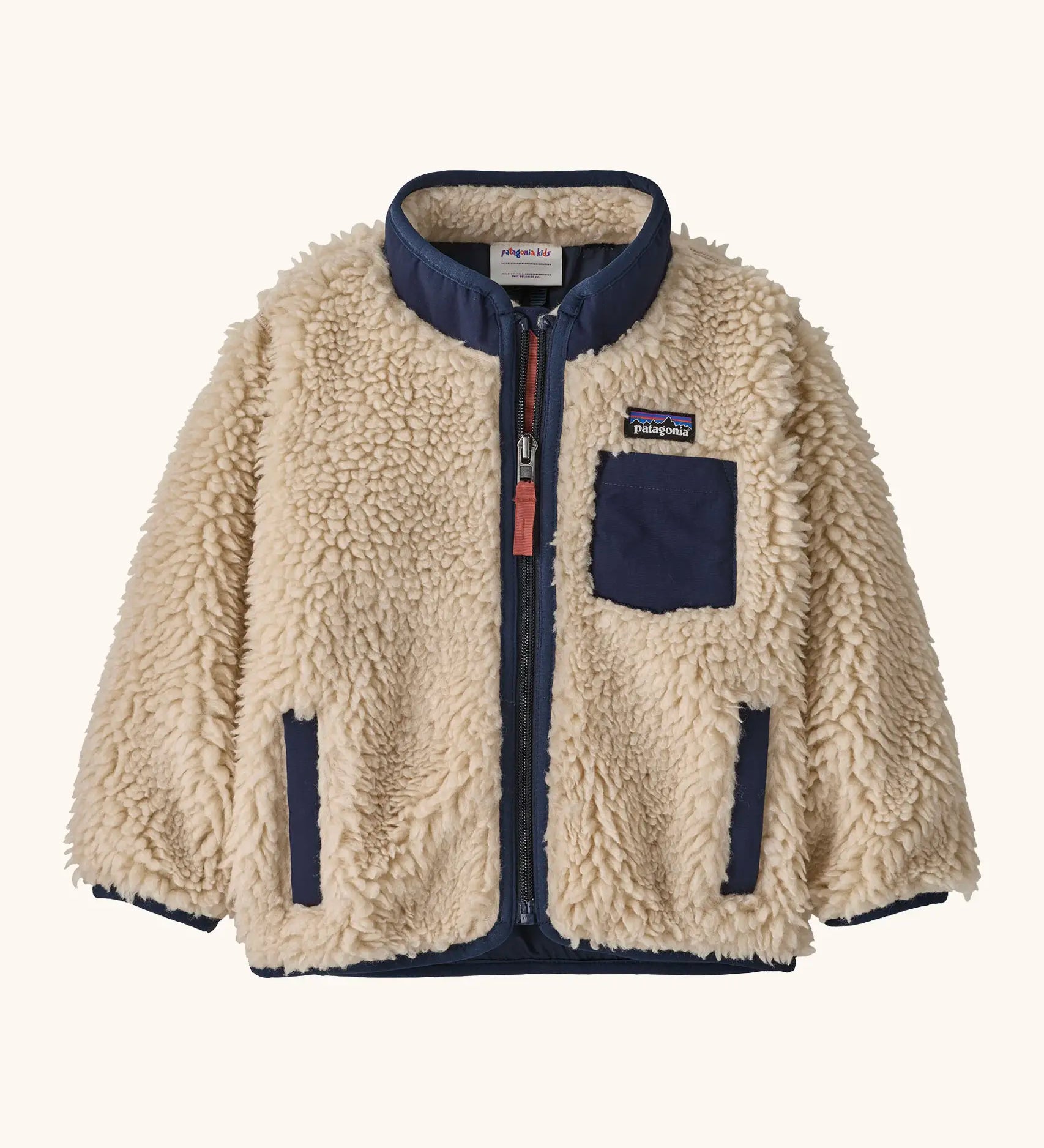 Patagonia little kids retro x pile fleece jacket in neutral with a navy trim. Shows a full front zip, side and chest pockets