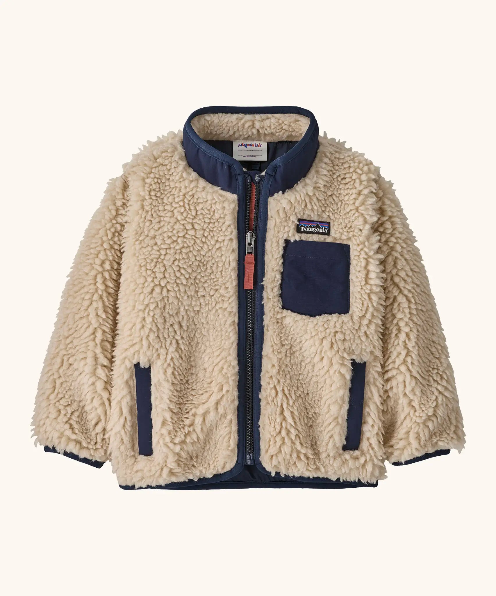 Patagonia little kids retro x pile fleece jacket in neutral with a navy trim. Shows a full front zip, side and chest pockets