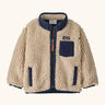 Patagonia little kids retro x pile fleece jacket in neutral with a navy trim. Shows a full front zip, side and chest pockets