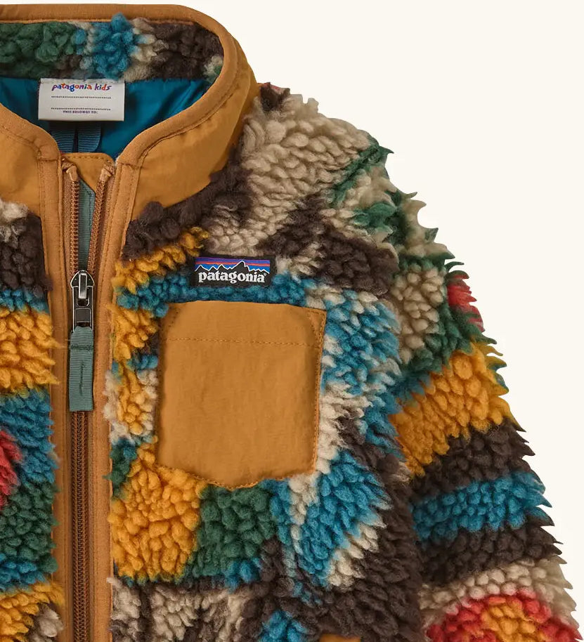 Patagonia little kids retro x pile fleece jacket with a colourful abstract pattern showing a close up of a brown turn up collar and chest pocket