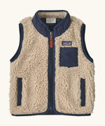Patagonia 100% recycled polyester little kids retro x high pile fleece vest in beige   with navy trim. Features a full length zip, side and chest pockets 
