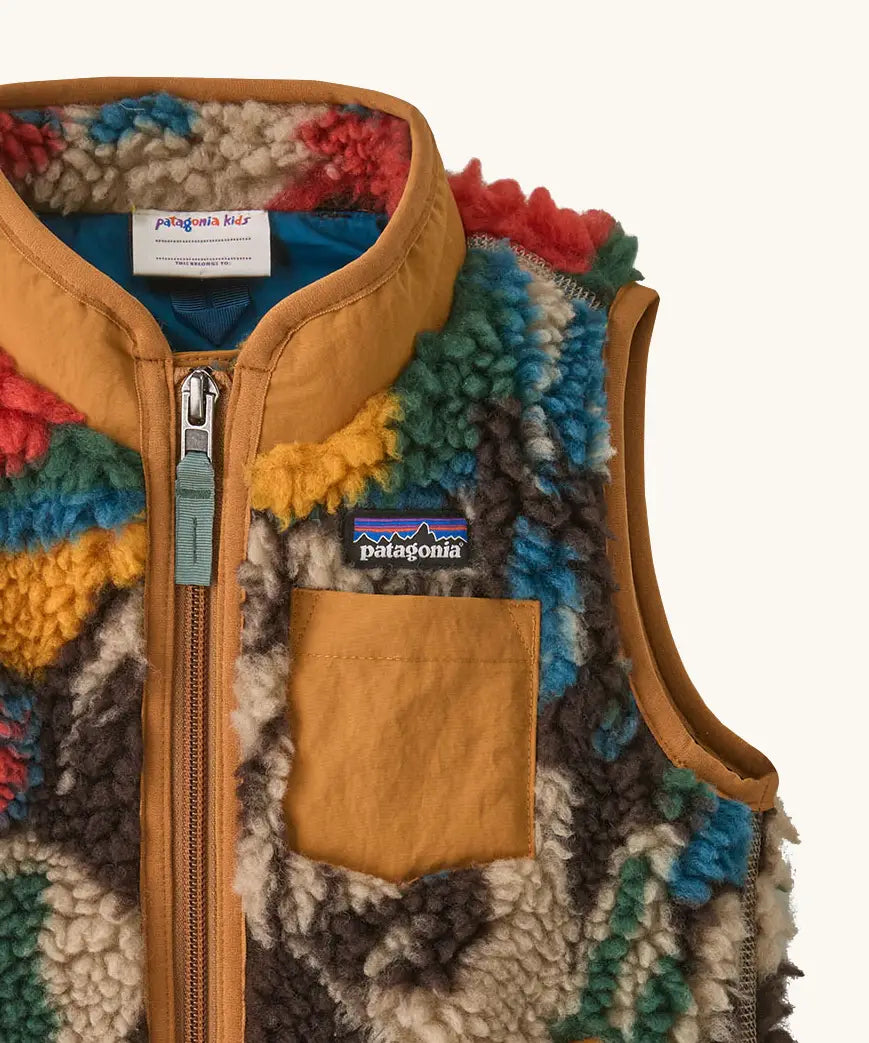 Patagonia 100% recycled polyester little kids retro x high pile fleece vest with abstract design showing close up of brown chest pocket and turn up collar