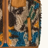 Patagonia 100% recycled polyester little kids retro x high pile fleece vest with abstract design showing close up the side pocket with brown trim