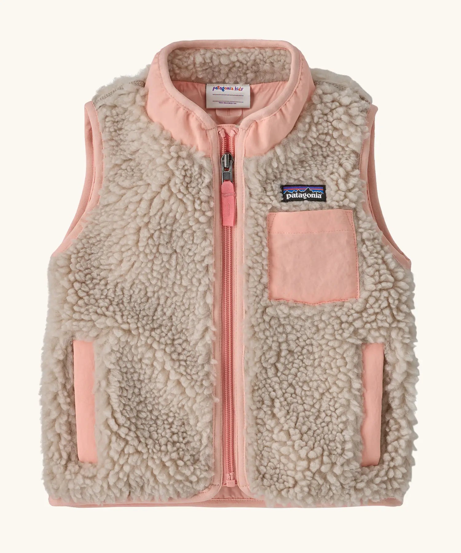 Patagonia 100% recycled polyester little kids retro x high pile fleece vest in beige   with pink trim. Features a full length zip, side and chest pockets 