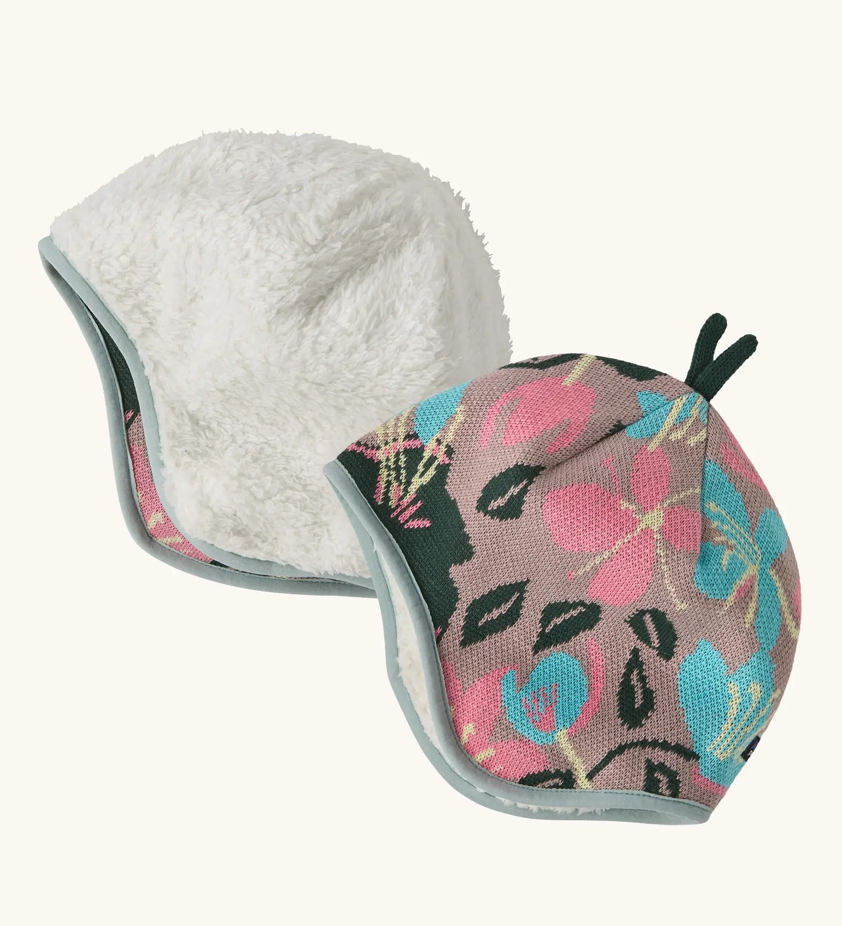 Patagonia baby cosy reversible beanie hat in hope blooms/fuzzy mauve showing a repeating knitted floral design and fleece pile 