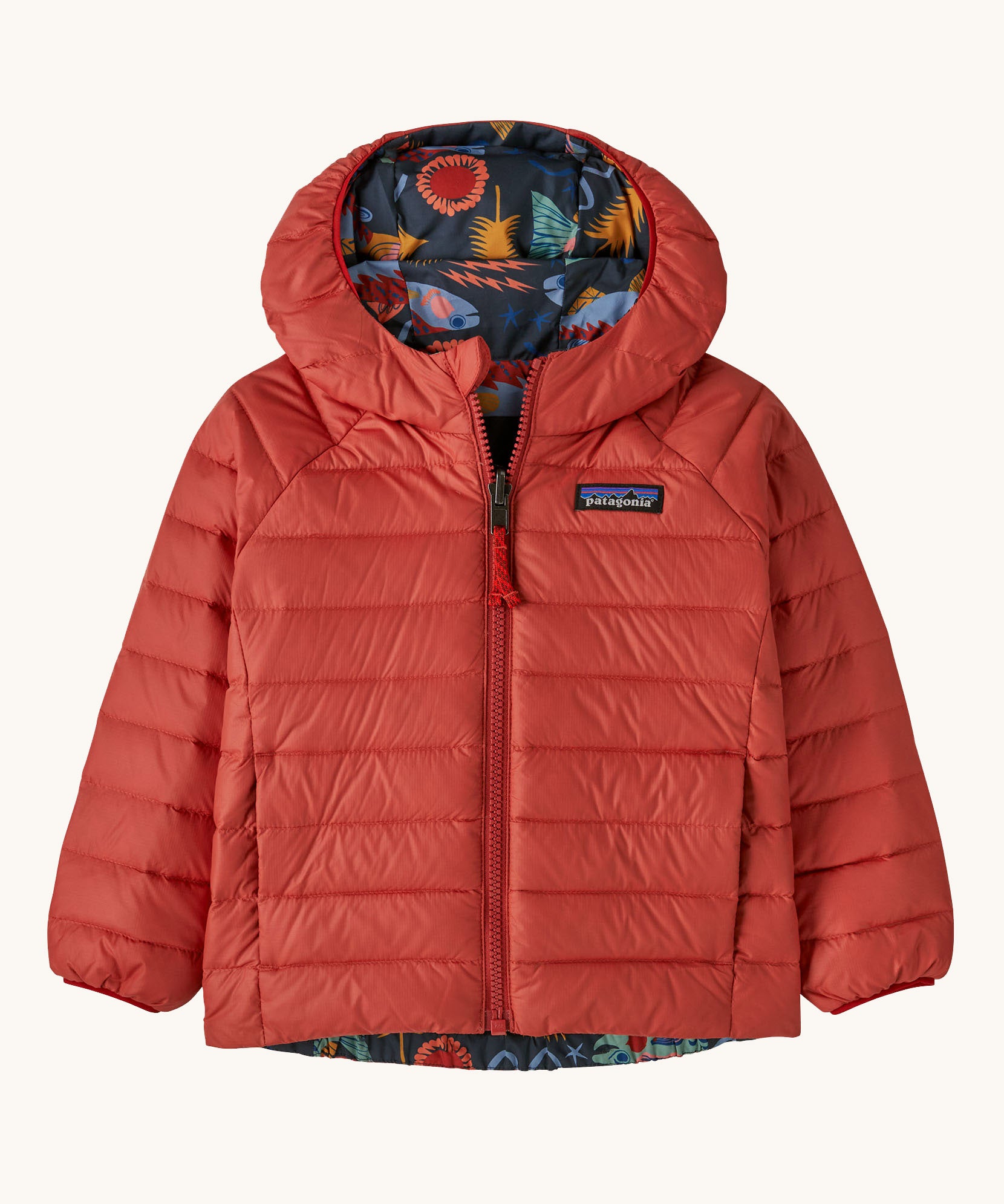 Patagonia little kids down hooded jacket in salmon energy ink black available at Babipur. A red warm reversible jacket with a funky salmon design on the reversible side. Features a a full length zip and 2 side pockets.