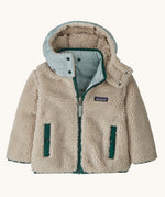 Patagonia little kids tribbles hoody. Showing the natural fleece alternative side. Features a full length zip, a logo patch on the chest and 2 side pockets 