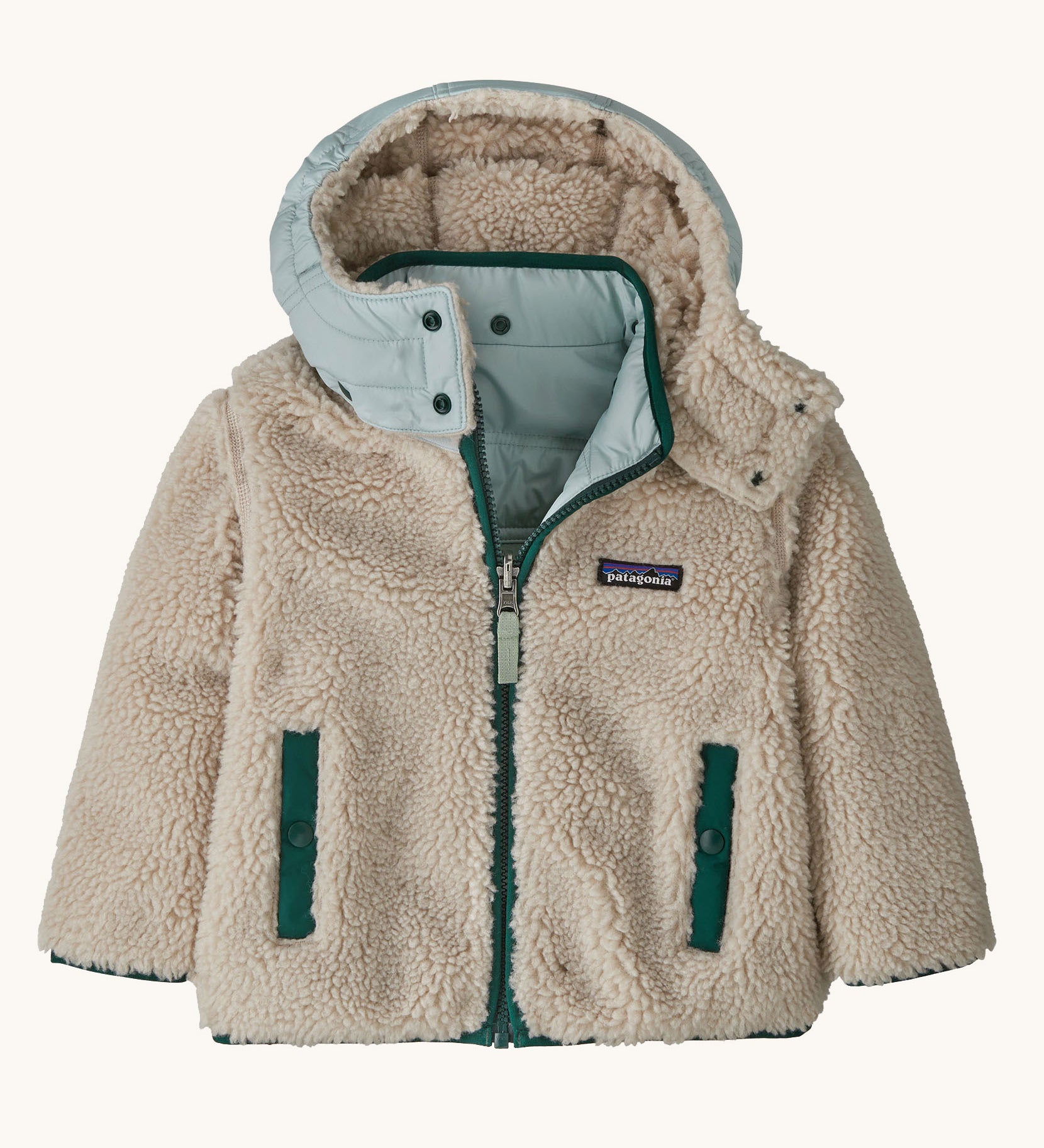 Patagonia little kids tribbles hoody. Showing the natural fleece alternative side. Features a full length zip, a logo patch on the chest and 2 side pockets 