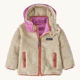 Patagonia little kids tribbles hoody. Showing the natural fleece alternative side with pale red trim. Features a full length zip, a logo patch on the chest and 2 side pockets 