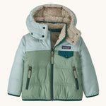 Patagonia little kids tribbles hoody available at Babipur. A reversible coat showing a green and blue hooded coat and natural fleece inner for warmth. Features a small chest pocket with popper fastening and 2 side zip pockets