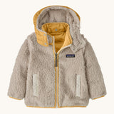 Patagonia little kids tribbles hoody. Showing the natural fleece alternative side with light yello trim. Features a full length zip, a logo patch on the chest and 2 side pockets 