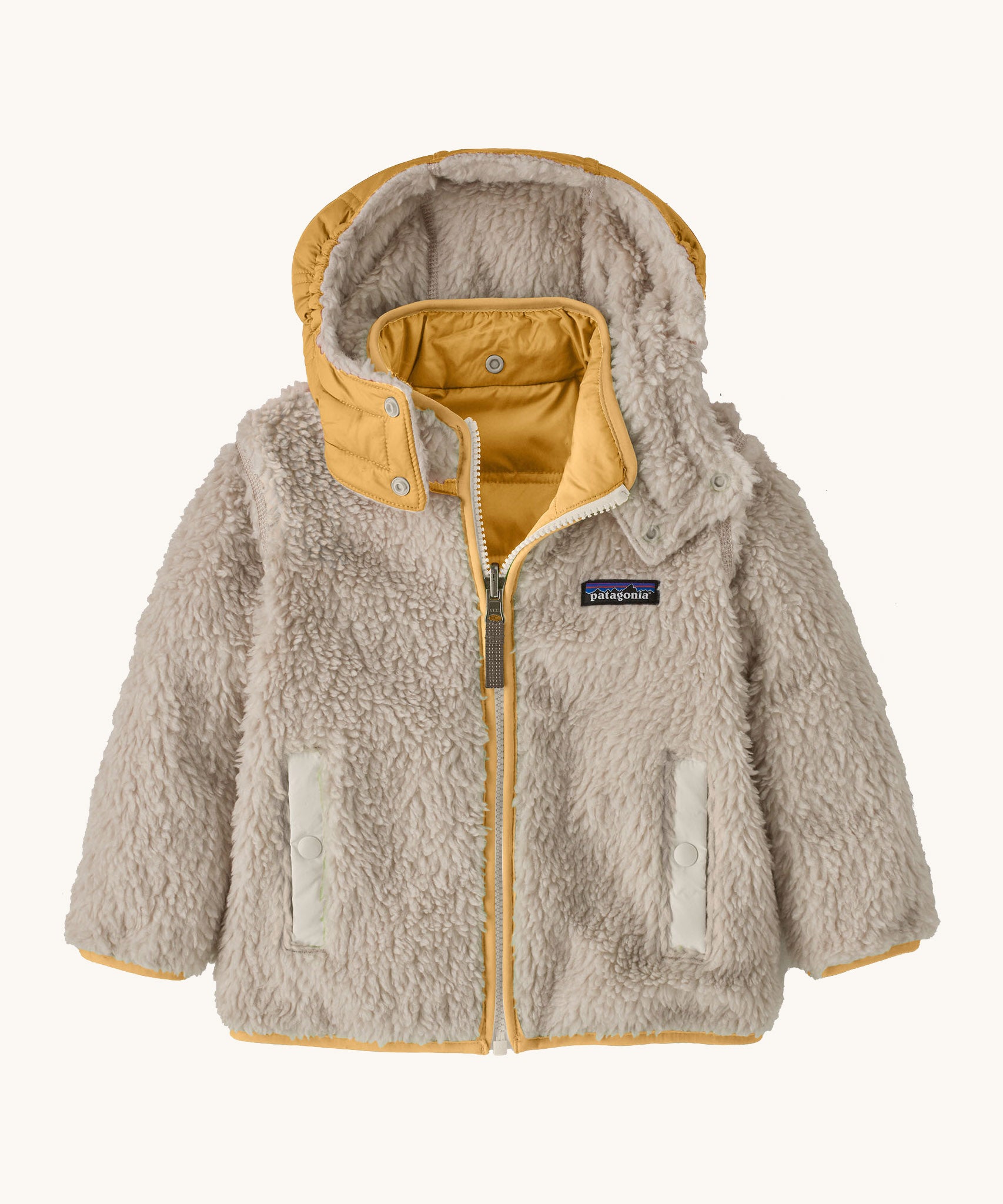 Patagonia little kids tribbles hoody. Showing the natural fleece alternative side with light yello trim. Features a full length zip, a logo patch on the chest and 2 side pockets 