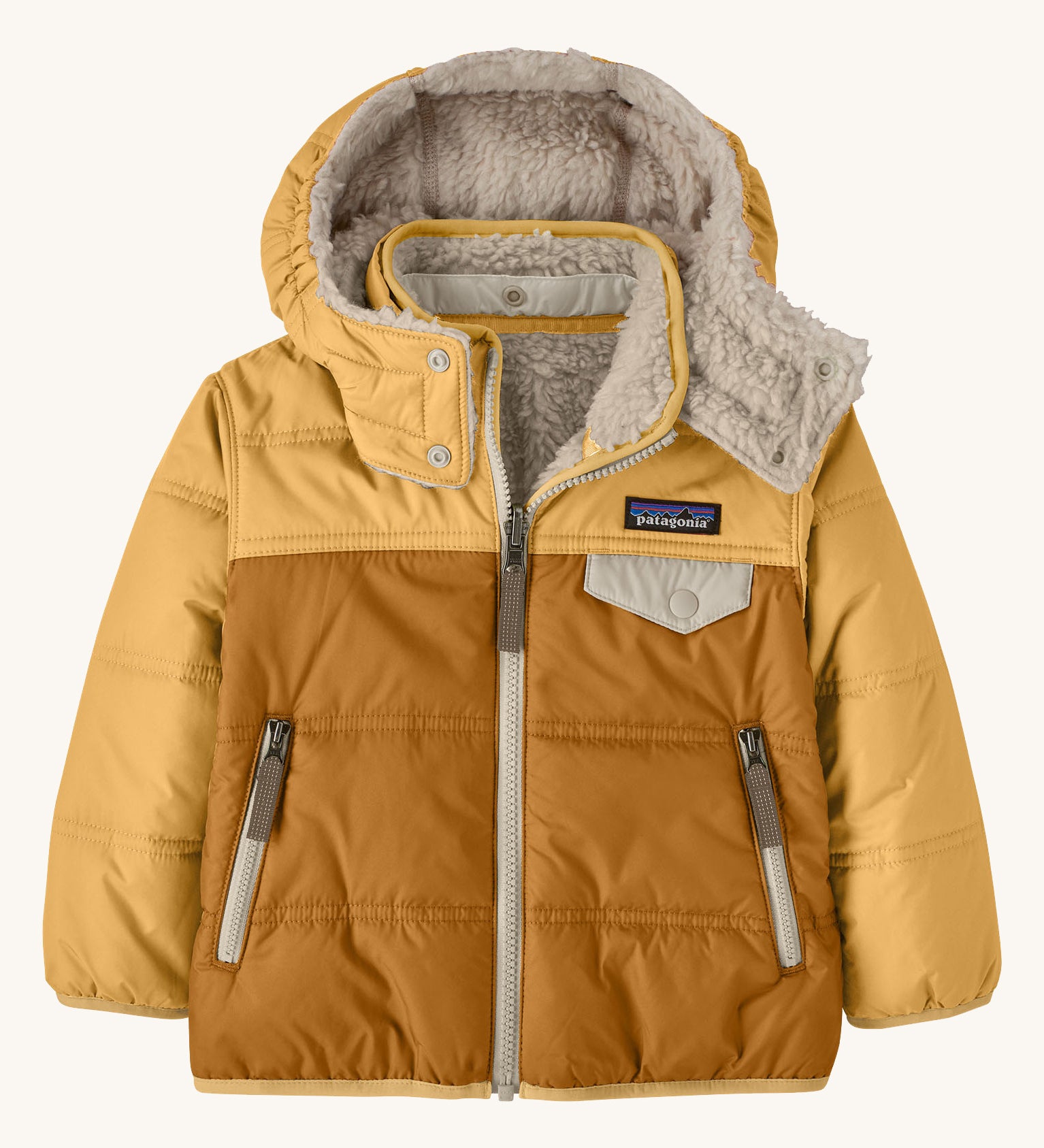 Patagonia little kids tribbles hoody available at Babipur. A reversible coat showing a dark and light yellow hooded coat and natural fleece inner for warmth. Features a small chest pocket with popper fastening and 2 side zip pockets