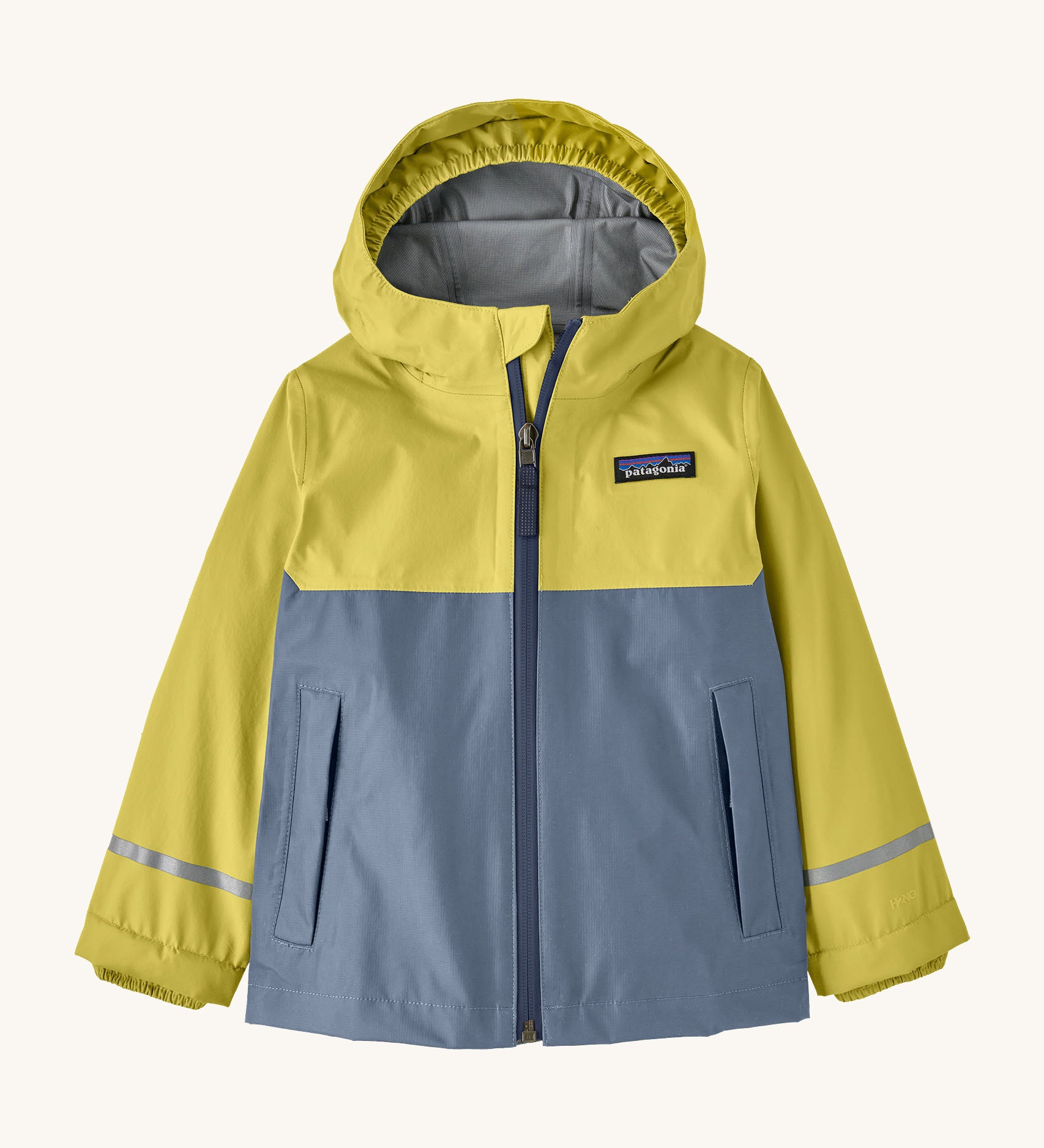 The Patagonia Little Kids Torrentshell 3L Waterproof Jacket in nearly green available at Babipur. A waterproof jacket in a yellow/grey and grey colourblock design. Features a full length zip, a hood with a elasticated cuff, 2 side pockets and a reflective strip on the cuffs