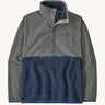 Patagonia Men's fleece pullover in grey and dark blue lower body. Features a 3/4 length front popper and a zipped pouch pocket .