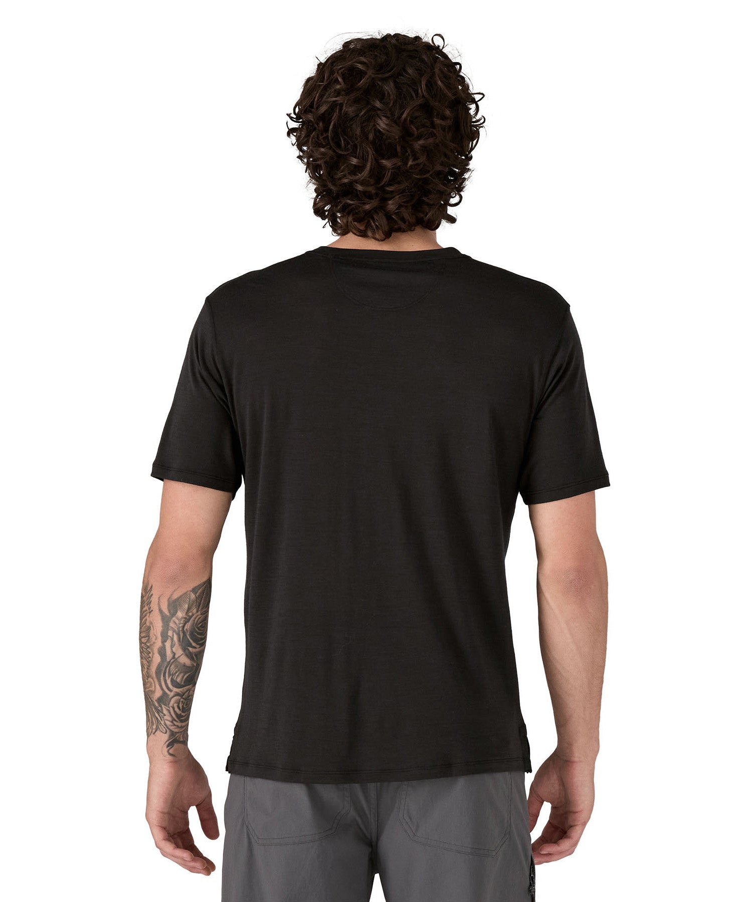 A man wearing the Patagonia Men's Capilene Cool Merino Graphic Shirt with a Heritage Header design in Black available at Babipur showing the back fit
