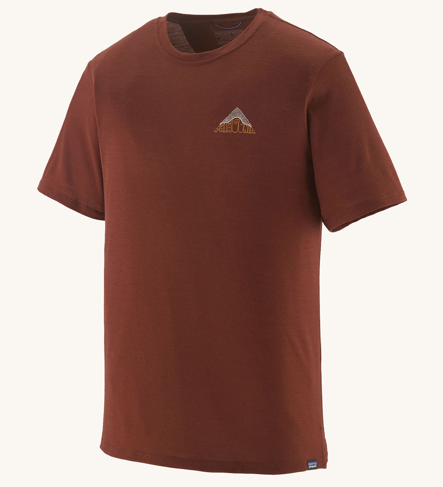 The Patagonia Men's Capilene Cool Merino Graphic Shirt in drift ways dried vanilla available at Babipur. A brown short sleeve top with a mountain graphic on the chest
