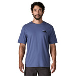 A man wearing the Patagonia Men's 73 Skyline Organic T-Shirt in current blue available at Babipur.
