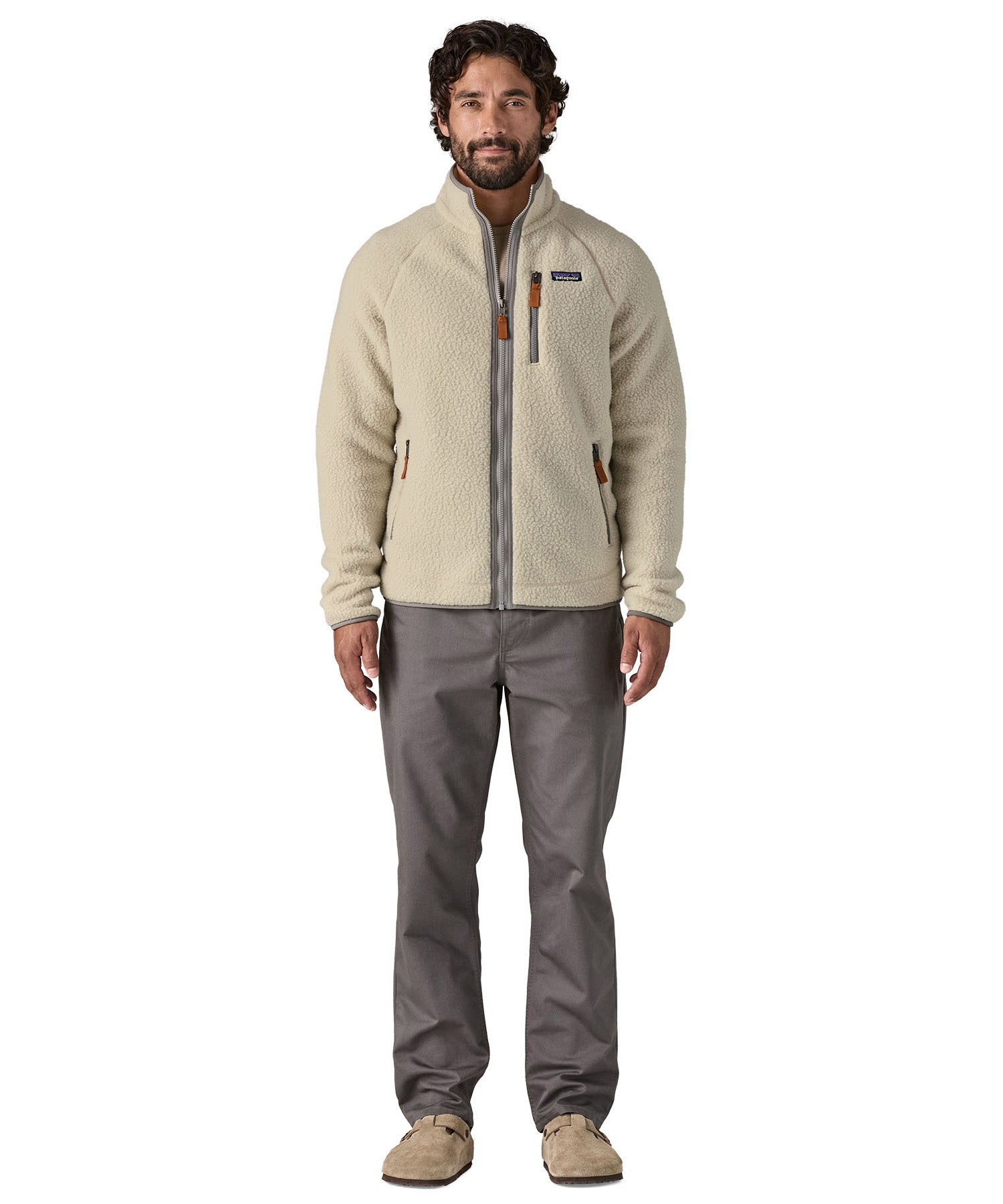 A man wearing the Patagonia Men's Retro Pile Fleece Jacket in a Pelican colour available at Babipur. A cream coloured fleece with grey trim. Features a full length zip