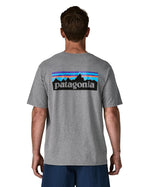 Man wearing Patagonia's men's responsibili t-shirt in grey with large logo patch on the upper back. T-shirt has a relaxed fit