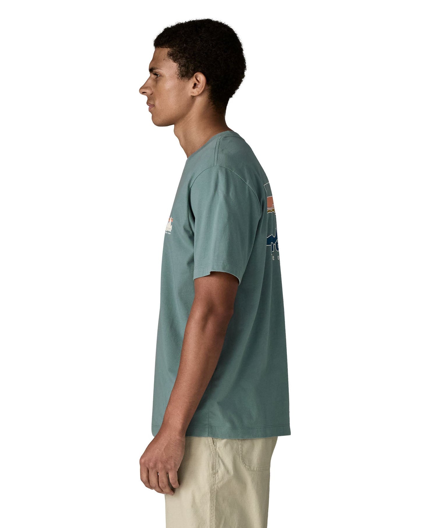 Side of man wearing Patagonia's 100% organic cotton 73 skyline t-shirt in light blue. T-shirt has relaxed fit 