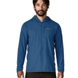 Man wearing Patagonia men's airshed pro pullover in blue. Top has a slim fit and sits around the hips