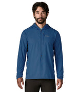 Man wearing Patagonia men's airshed pro pullover in blue. Top has a slim fit and sits around the hips