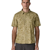 Man wearing Patagonia men's buttoned short sleeve shirt in light green. Shirt has a relaxed fit and sits at the hips