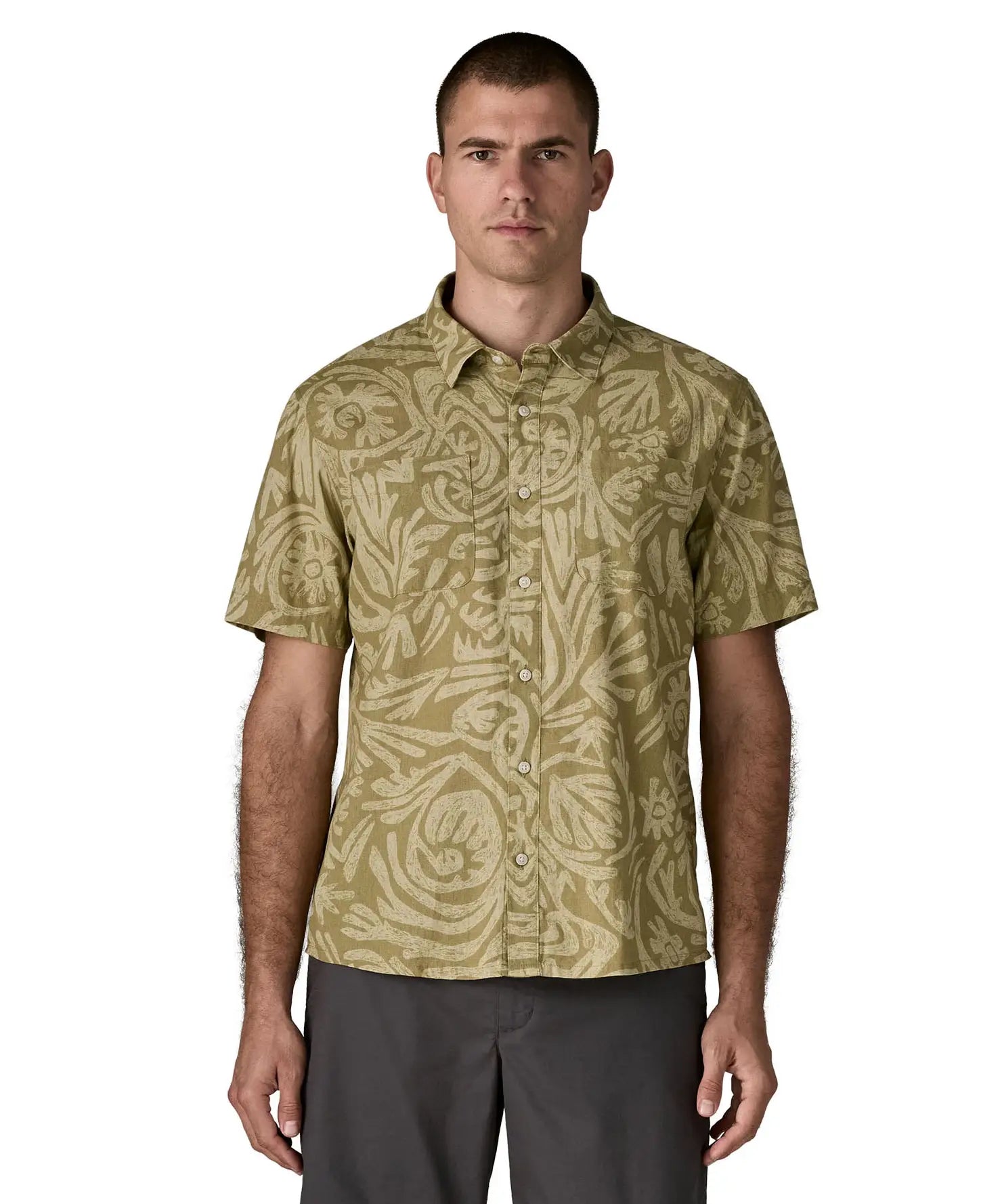 Man wearing Patagonia men's buttoned short sleeve shirt in light green. Shirt has a relaxed fit and sits at the hips