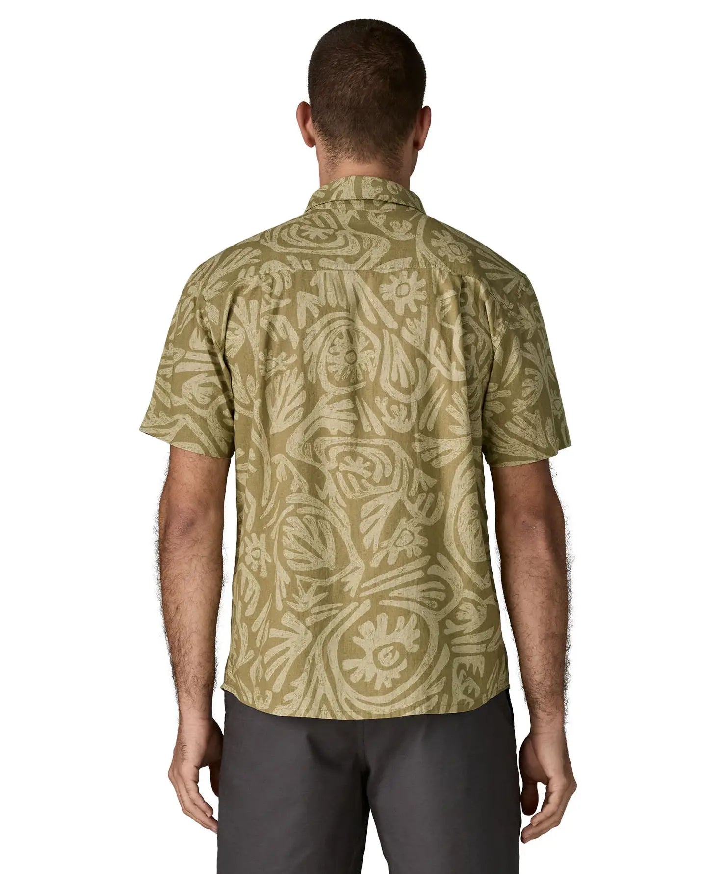 Back of man wearing Patagonia men's buttoned short sleeve shirt in light green. Shirt has relaxed fit and sits at the hips