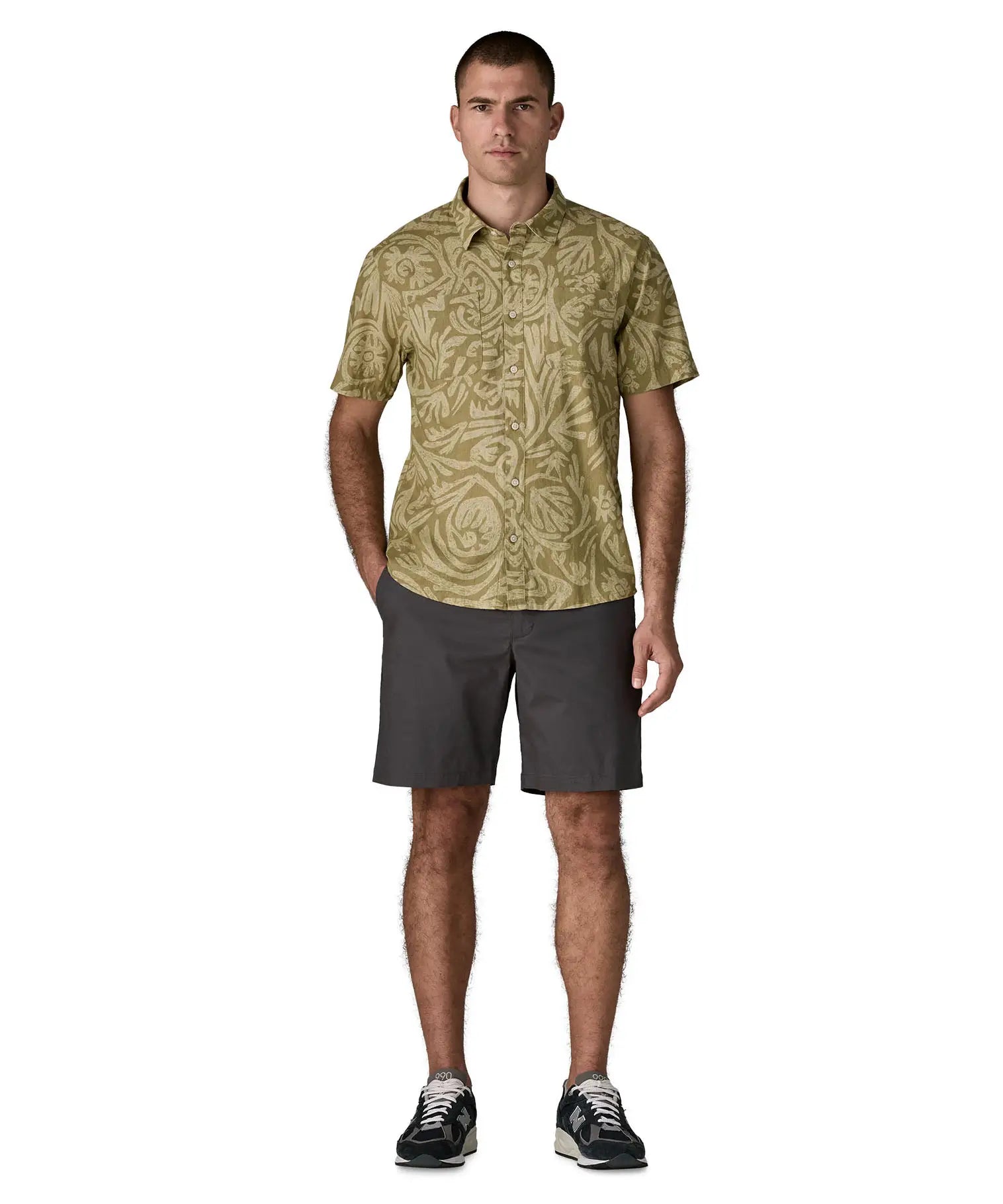 Man wearing Patagonia men's buttoned short sleeve shirt in light green with a repeating abstract pattern design. 