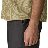 Hem of Patagonia men's buttoned short sleeve shirt in light green with a repeating abstract pattern design 
