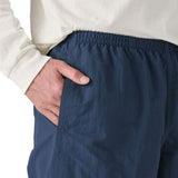 Man wearing Patagonia's men's baggies long 7 in shorts in dark blue with hand in side pocket