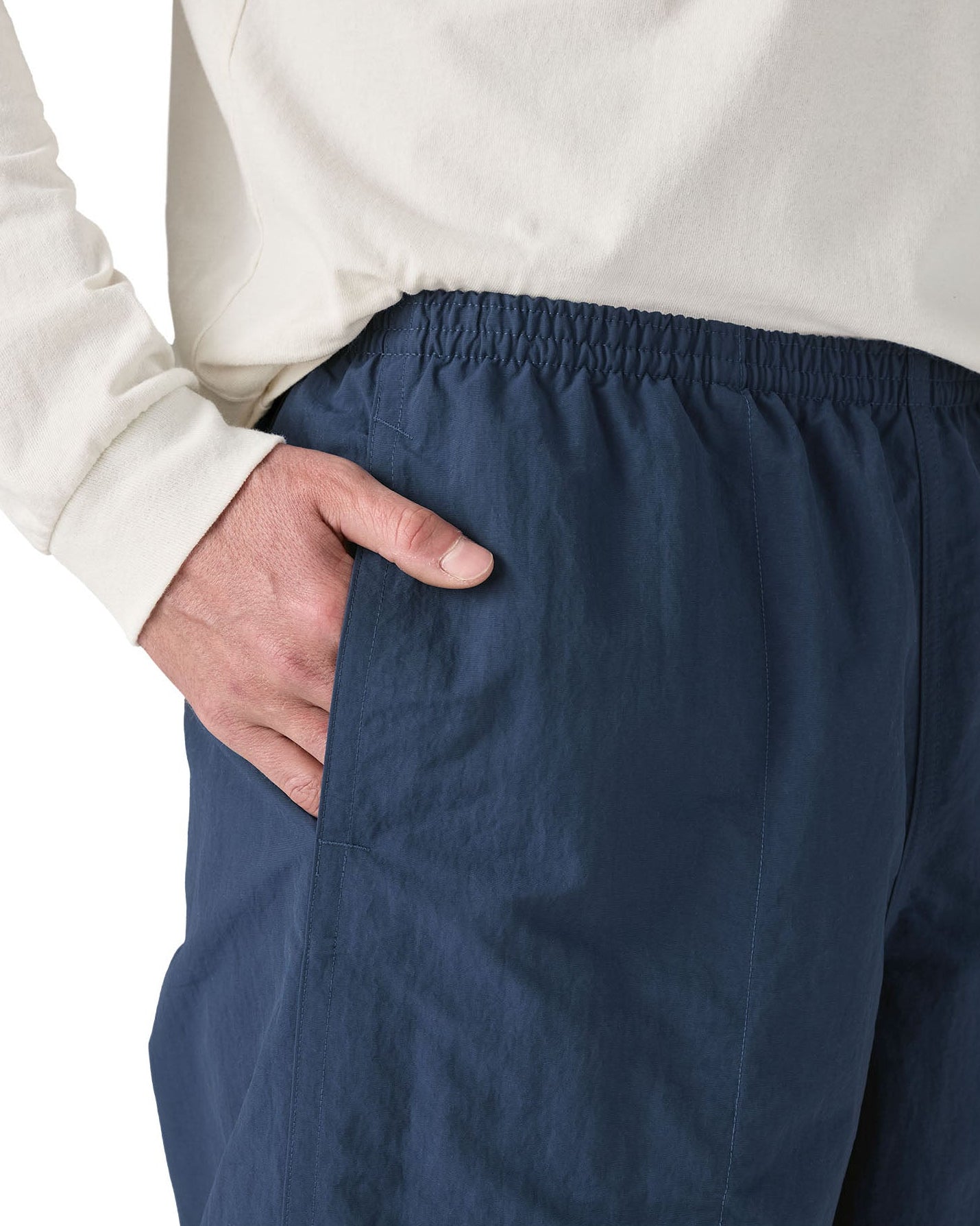 Man wearing Patagonia's men's baggies long 7 in shorts in dark blue with hand in side pocket