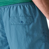 Patagonia's men's quick drying baggies shorts in light blue. Shows back pocket with popper fastener