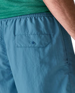 Patagonia's men's quick drying baggies shorts in light blue. Shows back pocket with popper fastener