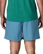 Back of man wearing Patagonia's men's  quick drying baggies shorts in light blue. Shorts have loose fitting and sit above the knees