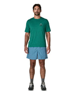Man wearing Patagonia's men's  quick drying baggies shorts in light blue. Shorts have loose fitting 