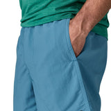 Man wearing Patagonias men's quick drying baggies shorts in light blue with hand in side pocket