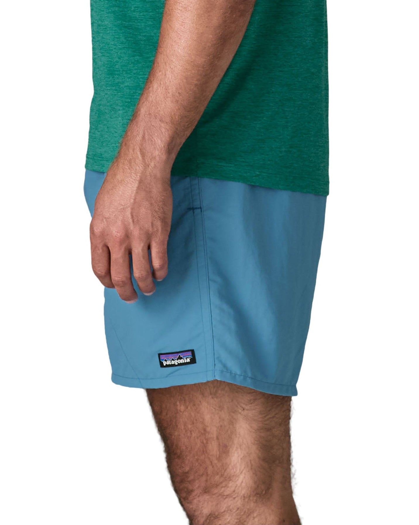 Side of man wearing Patagonia's men's  quick drying baggies shorts in light blue. Shorts have loose fitting and sit above the knees