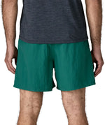 Back of man wearing Patagonia's men's  quick drying baggies shorts in teal green. Shorts have loose fitting and sit above the knees