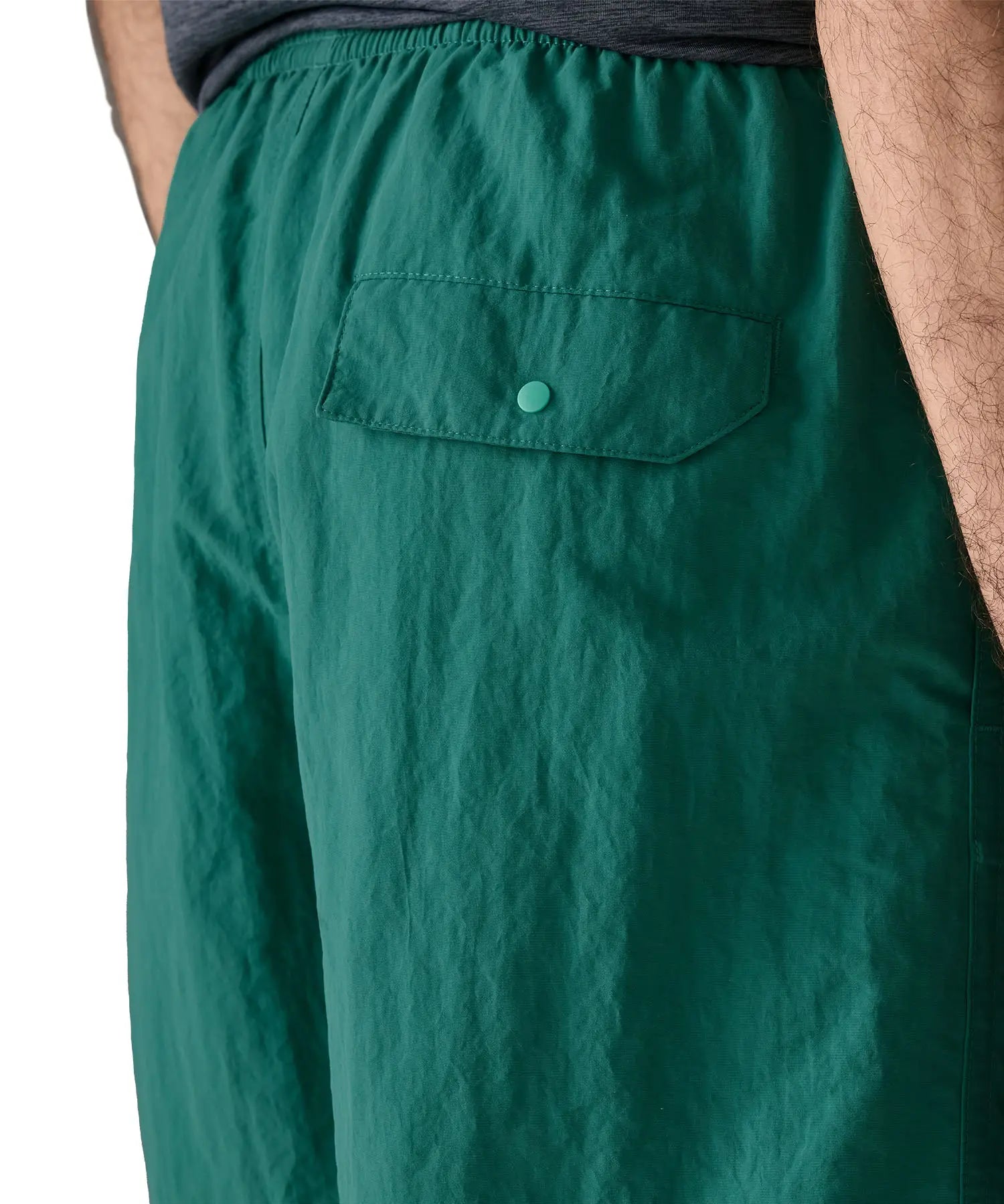 Patagonia's men's quick drying baggies shorts in teal green. Shows back pocket with popper fastener