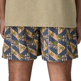 Back of man wearing Patagonia's men's  quick drying baggies shorts with repeating abstract tropical. Shorts have loose fitting and sit above the knees